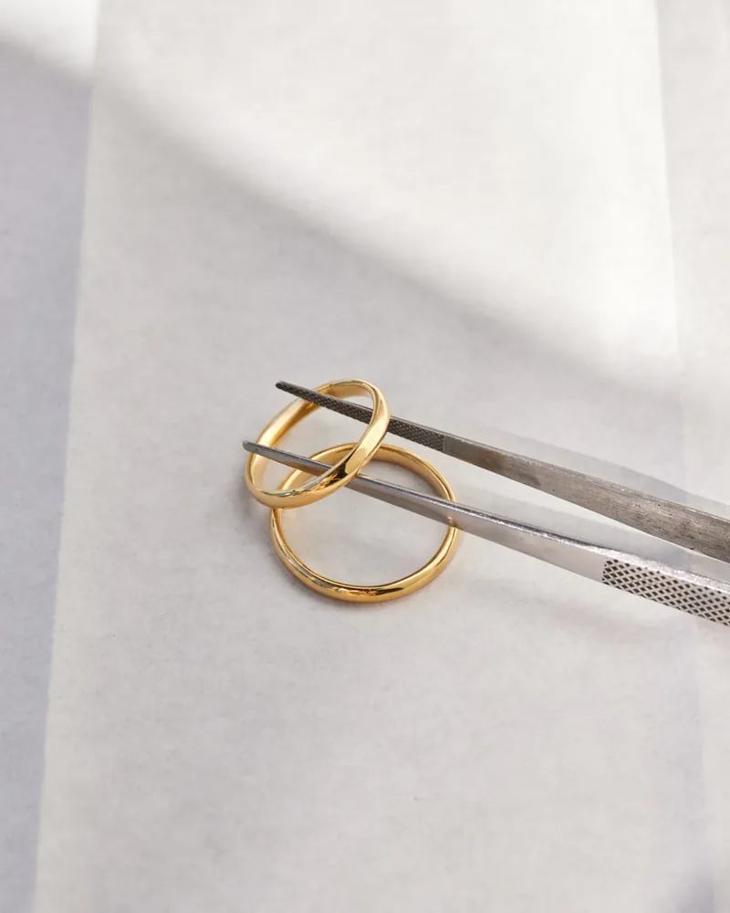 Goldener Ring, mit einer Pinzette gehalten