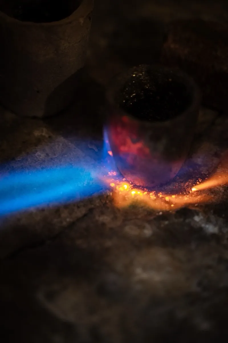 Blaue Flamme schmilzt Metall im Tiegel